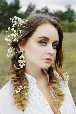 Close up portrait of woman face wearing floral white wreath outdoorsの写真素材