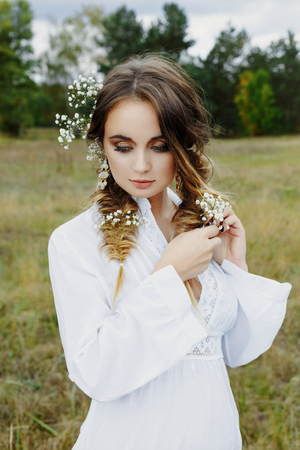Close up portrait of woman face wearing floral white wreath outdoorsの写真素材