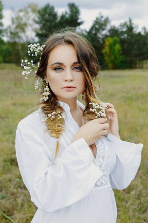 Close up portrait of woman face wearing floral white wreath outdoorsの写真素材