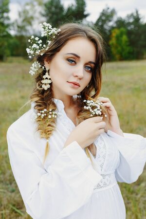 Close up portrait of woman face wearing floral white wreath outdoorsの写真素材