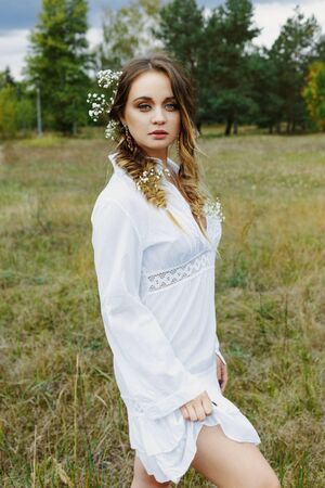 Close up portrait of woman face wearing floral white wreath outdoorsの写真素材