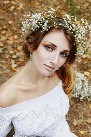 Close up portrait of woman face wearing floral white wreath outdoorsの写真素材