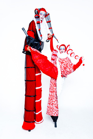 Two cheerful clown dressed in red and white cloth on a white backgroundの写真素材