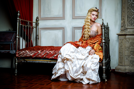 Retro baroque fashion blonde woman wearing gold dress.の写真素材