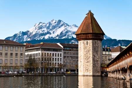 Mount Pilatus with tower and wooden chapel bridge in foreground, Lucerne, Switzerlandの写真素材