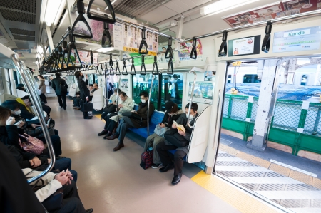 Tokyo, Japan - March 27, 2012: JR Chuo line local train of japan, stopped at Kanda station with some passengers in the car.のeditorial素材