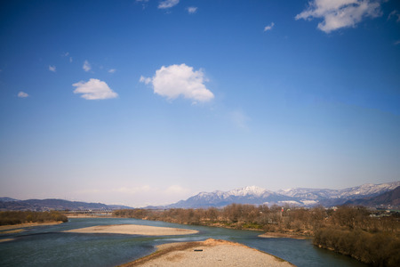 Dried river during winter in Japan with mountain view の写真素材