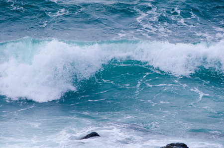 Big wave breaking on the rocks in the sea. Natural background.