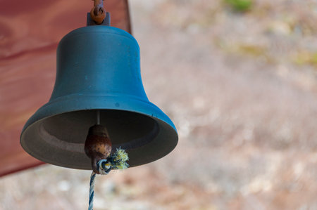 Close-up of a bell hanging on a rope with blurred background.の写真素材