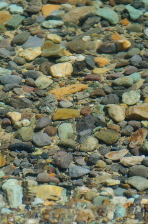 Colorful pebbles on the bottom and the shimmering surface of the water.