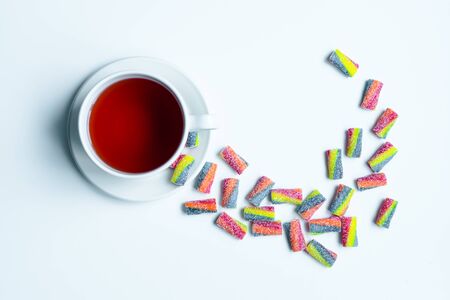 Cup of tea with colored sweets.の写真素材