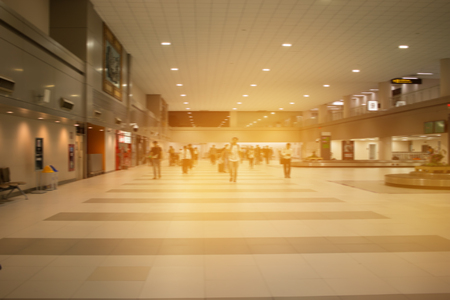 Large group people arriving and traveling carries luggage walking in airport terminal building waiting for check in. blurred crowd of traveler people on background. Traveling concept.の写真素材