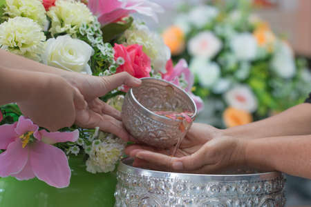 Songkran Thai festival concept : Thai people celebrate Songkran in new year water festival by giving garlands to elder seniors and asked for blessings to good life, Blur of Colorful Flowers backgroundの写真素材