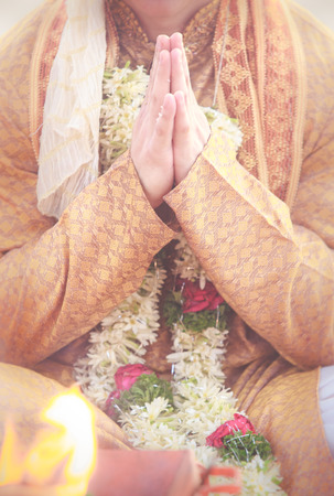 groom hands in namaste with wedding indian floral garlandの写真素材