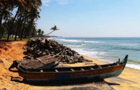 fish boat on a beach with palms in Indiaの写真素材