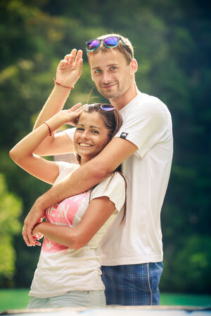 tall handsome man hold his pretty brunette girl  stand on longtail boat and take off sunglasesの写真素材