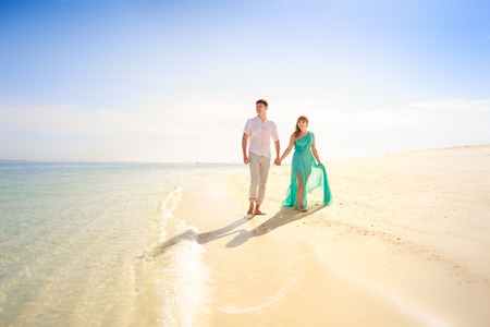 young handsome man walk with beautiful blonde girlfriend in blue dressの写真素材