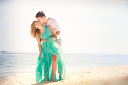 young handsome man hold his beautiful blonde girlfriend in blue dressの写真素材
