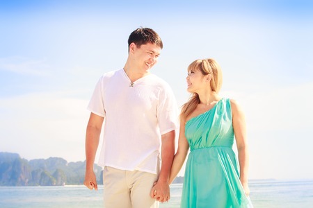 young handsome man walk with beautiful blonde girlfriend in blue dressの写真素材