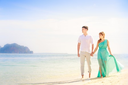 young handsome man walk with beautiful blonde girlfriend in blue dressの写真素材