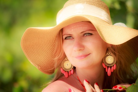 blonde long haired blue eyed girl in straw hat portrait closeupの写真素材