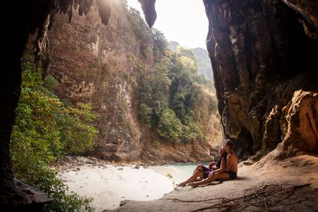 woman and man half dressed sit in caveの写真素材