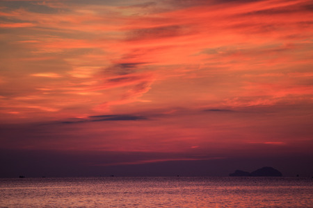 panorama of fantastic beautiful red fleecy clouds before sunrise and sea on foregroundの写真素材