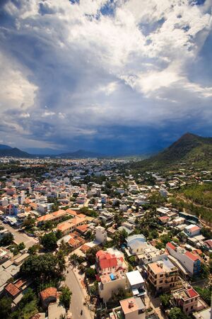 upper panorama of resort city with red and white roofs against hills blue sky and fantastic white cloudsの写真素材