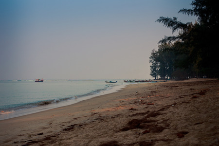 panorama of boats in tranquil azure sea wave surf and plane sand beach on foregroundの写真素材