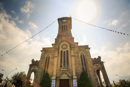 NHA TRANG, KHANH HOA / VIETNAM - FEBRUARY July 2016: Large old Catholic cathedral with tower decorated with flags in Vietnam on February 07 in Nha trangのeditorial素材