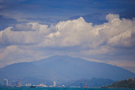 panorama of resort city against distant mountain and azure sea boats blue sky with white cloudsの写真素材