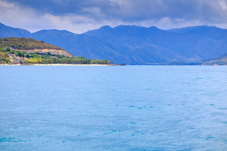panorama of big clouds lace in blue sky above azure sea green hillの写真素材