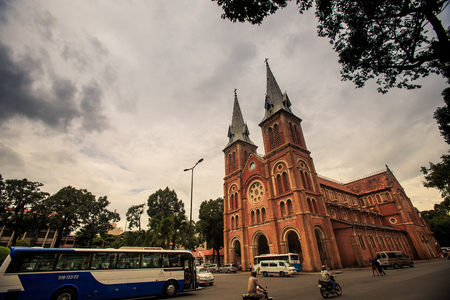 HO CHI MINH / VIETNAM - MARCH 17 2016: Old beautiful building of the catholic church in the street with small traffic against the sky in Saigon on March 17 in Ho Chi Minhのeditorial素材