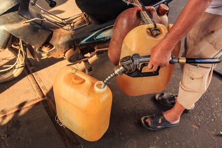 closeup man hand holds filling device refuelingの写真素材