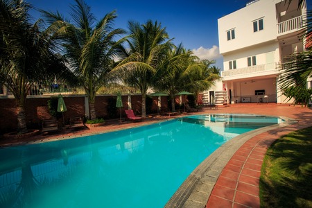 blue transparent water swimming pool with palm treesのeditorial素材