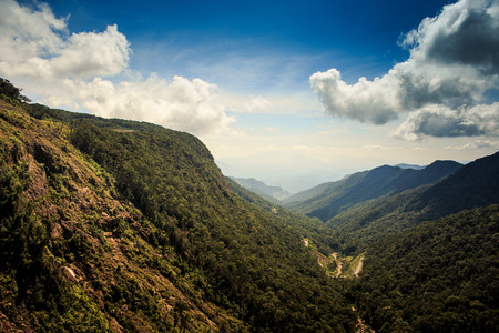 magnificent view great gorge between large steep green and brown mountains against blue sky and white cloudsの写真素材