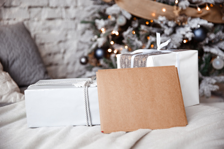 Kraft envelope is lying on the bed against the the Christmas treeの写真素材