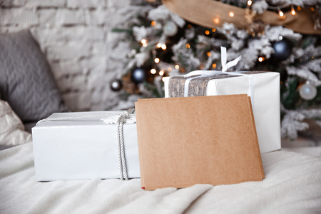 Kraft envelope is lying on the bed against the the Christmas treeの写真素材