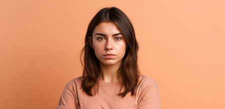 young brunette woman over isolated background keeping the arms crossed in frontal positionの素材
