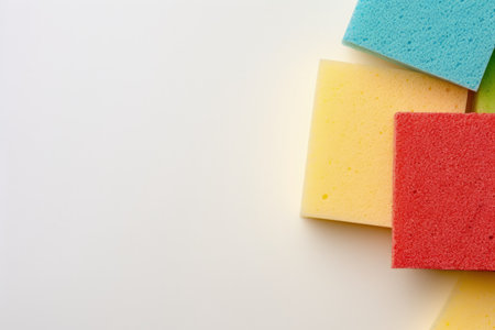 Flat lay of colorful sponges on cream paper top view with empty spaceの素材