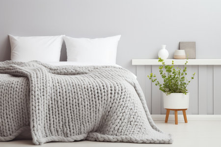 Cozy stylish Scandinavian room with a grey stucco wall featuring a white and grey knitted woolen blaの素材