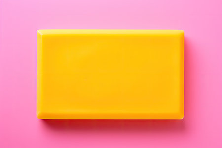 Yellow soap bar surrounded by foam with copy space in the center isolated on a bright pink backgrounの素材