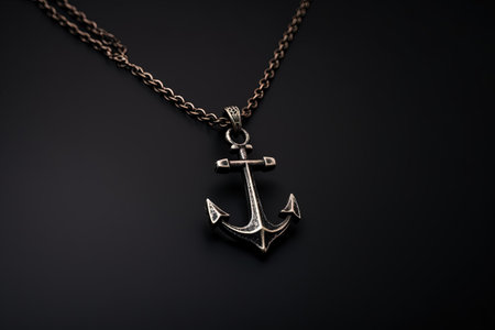 Metallic small anchor necklace on black background Symbolizes sailors reliability and confidence Navの素材