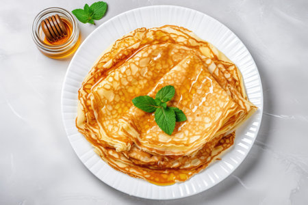 Crepes pancakes with honey on white plate Marble background Top viewの素材