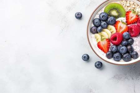 Bird s eye view of fruit and yogurt with cereal kiwi strawberries banana blueberries and raspberriesの素材