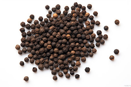 Isolated pile of black peppercorns from a top view on a white backgroundの素材