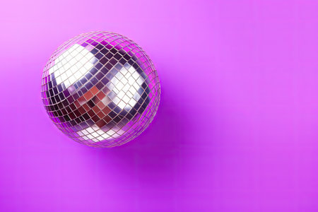 Top view of a violet background with a shiny disco ball Room for textの素材