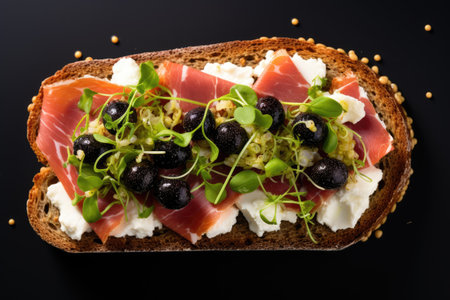 Breakfast sandwich with cream cheese salami black olives micro greens top view close up no peopleの素材