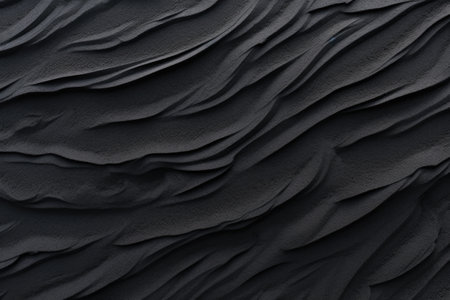 Macro photography of black sand dunes on a beach capturing the texture and wave pattern of the blackの素材