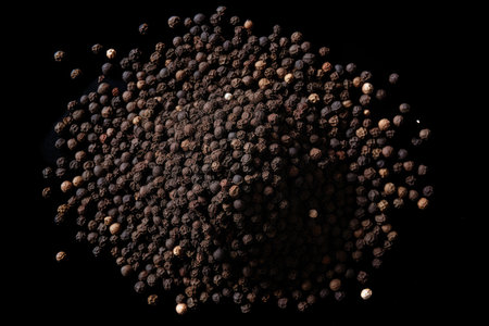 Top view of ground black pepper on white surface resembling scattered sandの素材